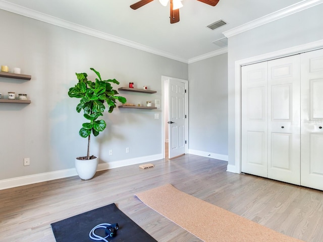 exercise area featuring ceiling fan, light hardwood / wood-style floors, and crown molding