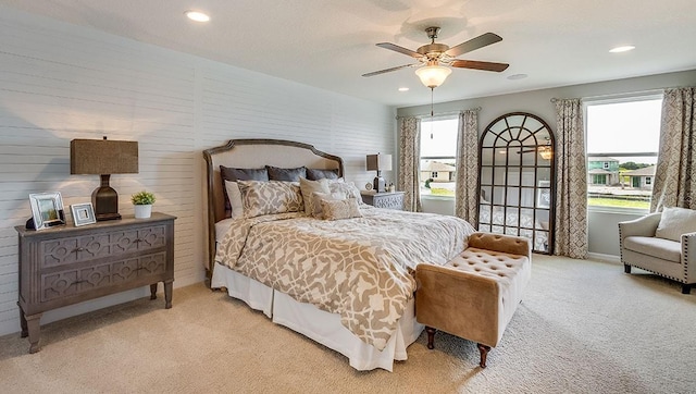 carpeted bedroom with ceiling fan and multiple windows