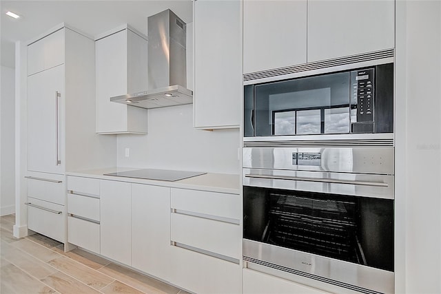 kitchen featuring stainless steel appliances, light countertops, white cabinetry, modern cabinets, and wall chimney exhaust hood