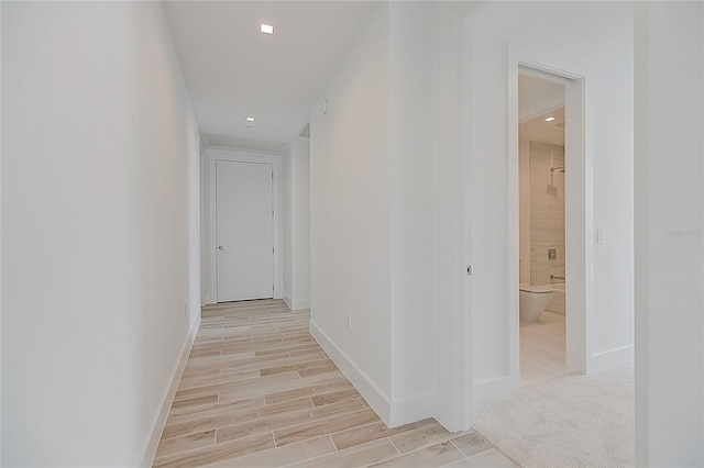 corridor with baseboards and wood finish floors