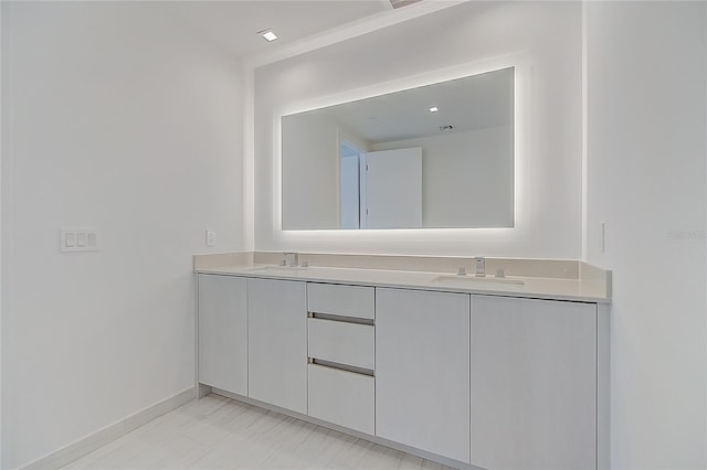 bathroom featuring a sink, baseboards, and double vanity