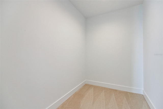 carpeted spare room featuring baseboards