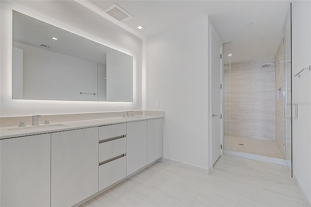 bathroom featuring double vanity, a stall shower, a sink, and visible vents