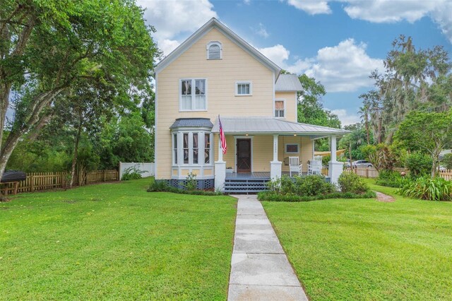 view of front of house with a front yard and covered porch