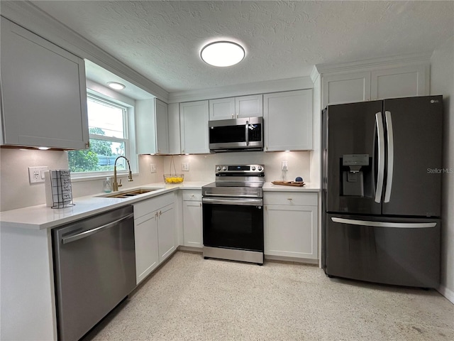 kitchen with a textured ceiling, white cabinets, sink, and appliances with stainless steel finishes