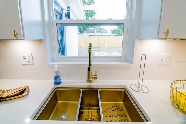 interior details featuring white cabinetry and sink