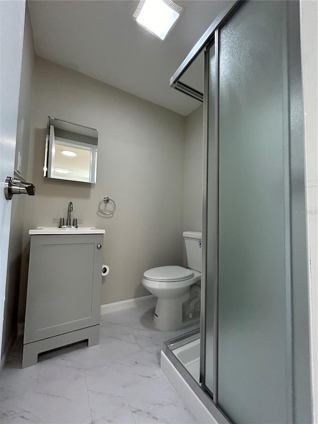 bathroom featuring vanity, toilet, and a shower with shower door