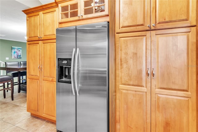 kitchen with ornamental molding, light tile patterned floors, and stainless steel fridge with ice dispenser