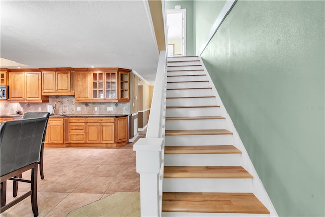 staircase with tile patterned floors and sink