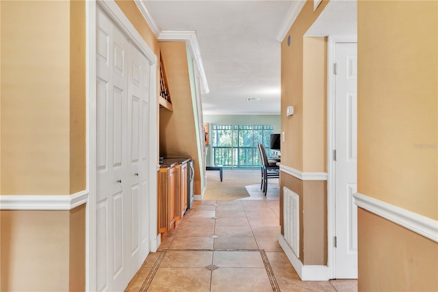 corridor featuring crown molding and light tile patterned floors