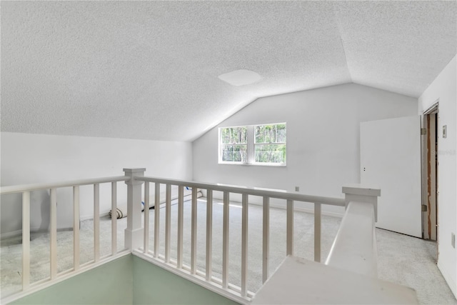 interior space featuring a textured ceiling, carpet, and vaulted ceiling