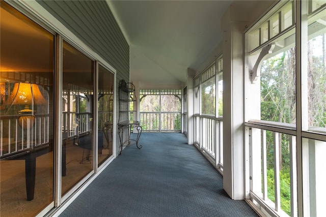 unfurnished sunroom featuring lofted ceiling and plenty of natural light