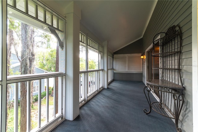 sunroom / solarium featuring lofted ceiling and a healthy amount of sunlight