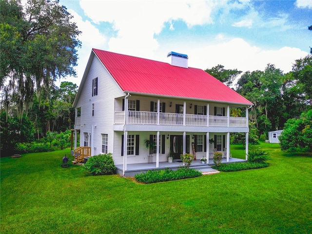 rear view of property featuring a patio, a balcony, and a lawn