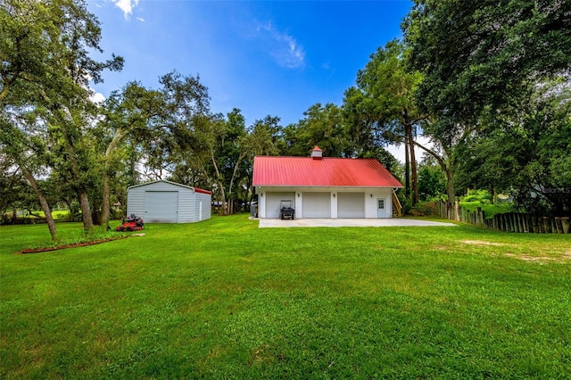 view of yard featuring a garage and an outbuilding