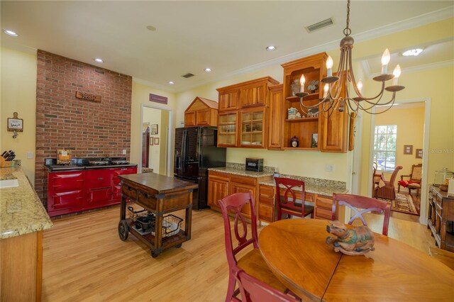 kitchen with an inviting chandelier, light hardwood / wood-style flooring, pendant lighting, and black fridge