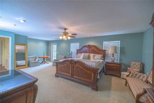 bedroom featuring a textured ceiling, ceiling fan, and light carpet