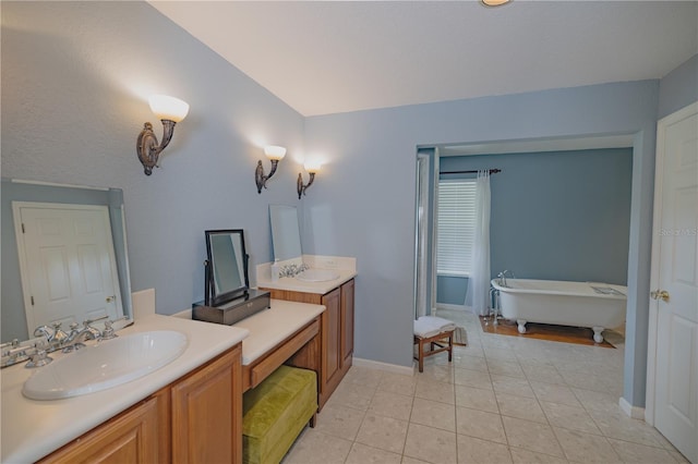 bathroom featuring a bath, tile patterned flooring, and dual bowl vanity