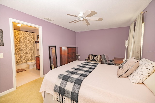 bedroom featuring ceiling fan, light tile patterned floors, and ensuite bath