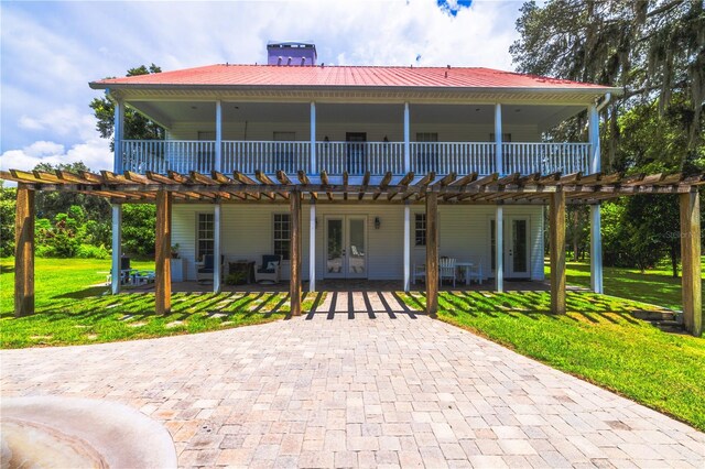 back of property featuring a lawn, a pergola, a patio, and french doors