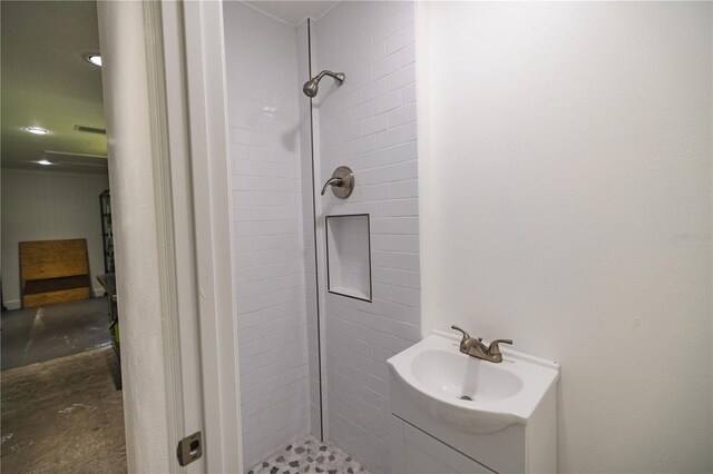 bathroom featuring vanity and tiled shower