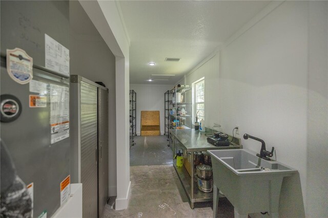 hall with crown molding and concrete flooring