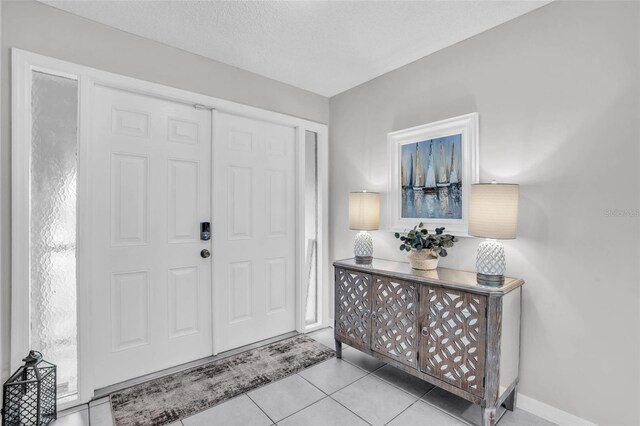 tiled entrance foyer featuring a textured ceiling