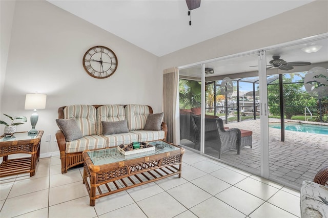 tiled living room with ceiling fan and vaulted ceiling