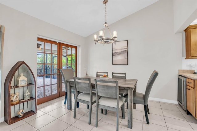 dining space with lofted ceiling, light tile patterned floors, a notable chandelier, and french doors