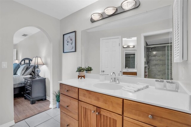 bathroom with hardwood / wood-style flooring, vanity, and a shower with shower door