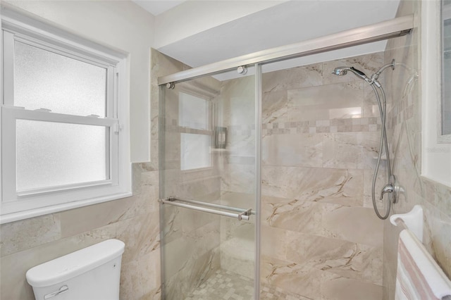 bathroom with an enclosed shower, tile walls, and toilet