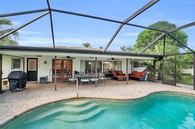 view of swimming pool with french doors, grilling area, a lanai, ceiling fan, and an outdoor living space