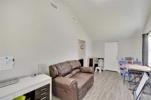 living room with light hardwood / wood-style flooring and high vaulted ceiling