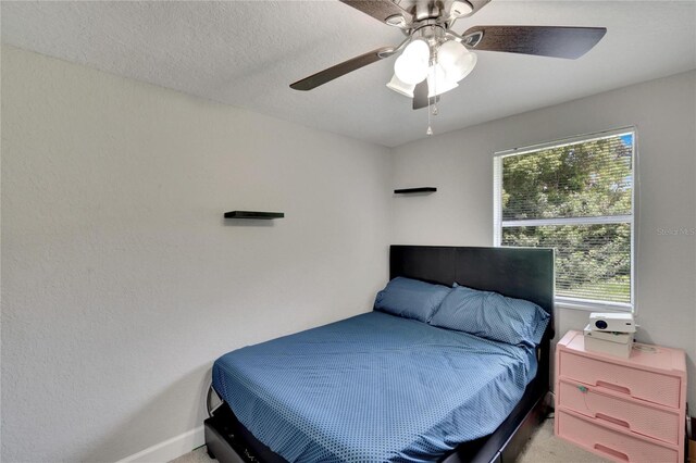 bedroom with ceiling fan, light carpet, and baseboards