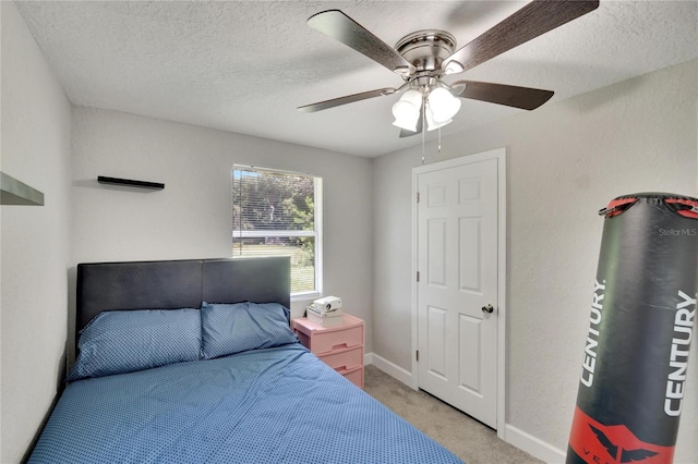 bedroom featuring ceiling fan, baseboards, a textured ceiling, and light colored carpet