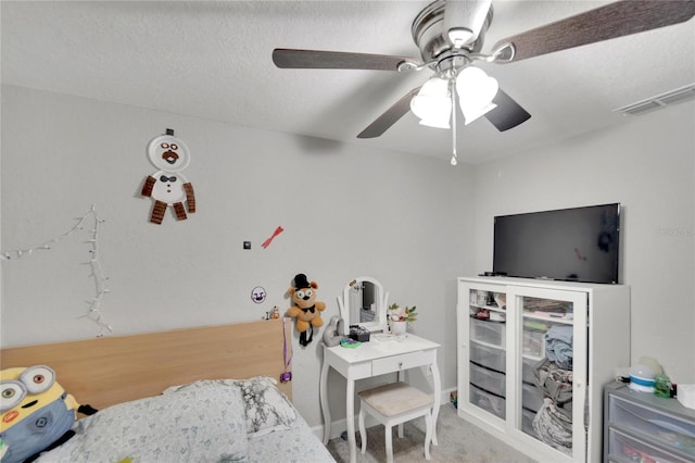 bedroom with ceiling fan, carpet flooring, and a textured ceiling