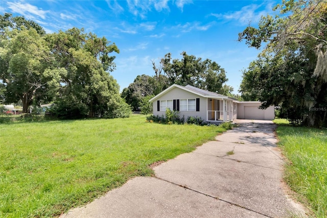 view of front facade featuring a detached garage and a front lawn