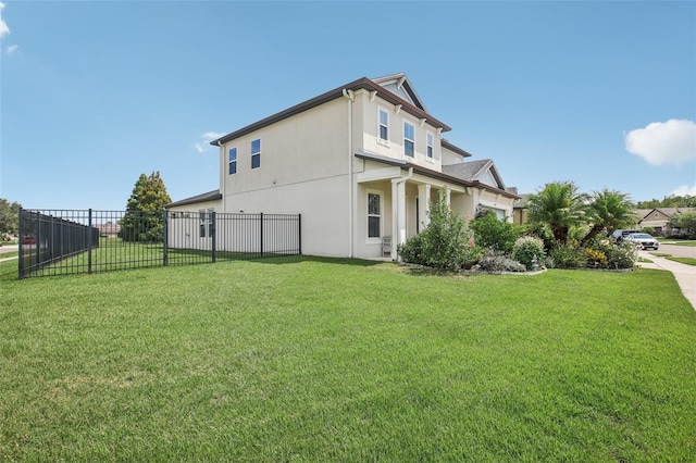 view of property exterior with stucco siding, a yard, and fence