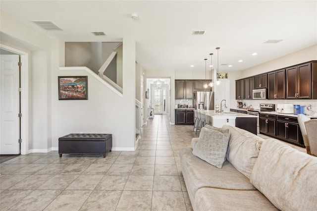 living room featuring light tile patterned flooring, baseboards, and visible vents