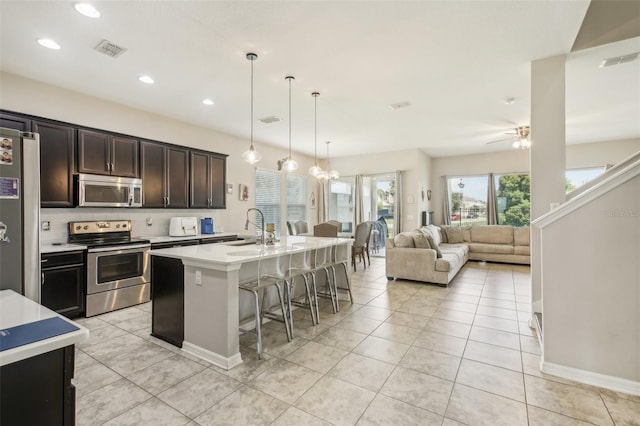 kitchen with stainless steel appliances, visible vents, a breakfast bar area, and light countertops