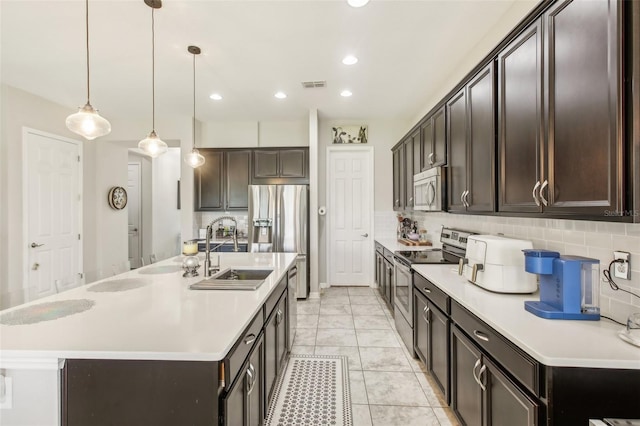 kitchen with visible vents, a sink, stainless steel appliances, light countertops, and dark brown cabinets