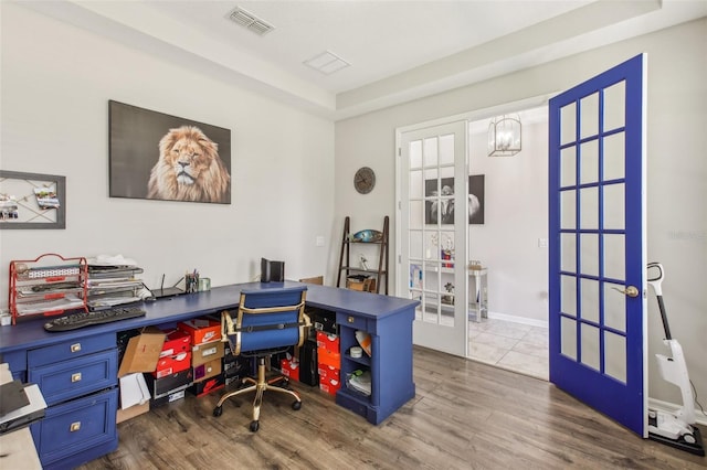 office featuring a chandelier, visible vents, french doors, and wood finished floors