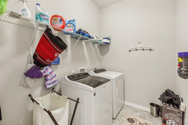 washroom featuring baseboards, independent washer and dryer, and laundry area