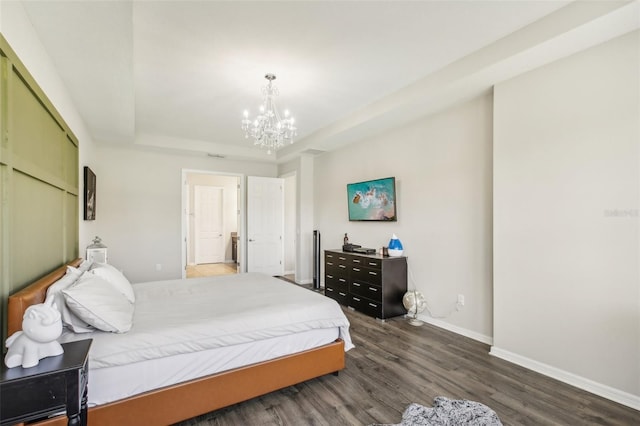 bedroom with an inviting chandelier, a raised ceiling, baseboards, and wood finished floors