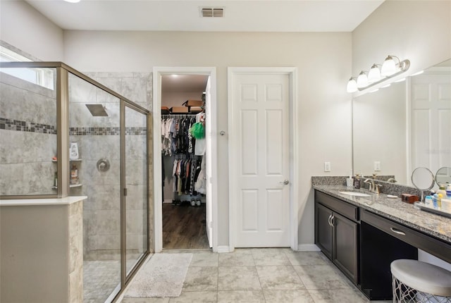 bathroom featuring hardwood / wood-style floors, walk in shower, and vanity