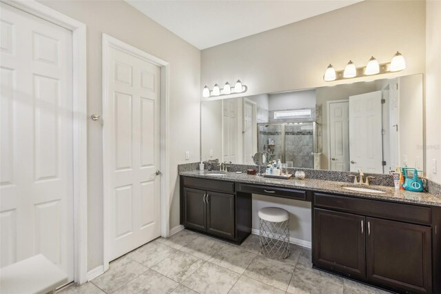 bathroom featuring a sink, double vanity, a shower stall, and tile patterned flooring