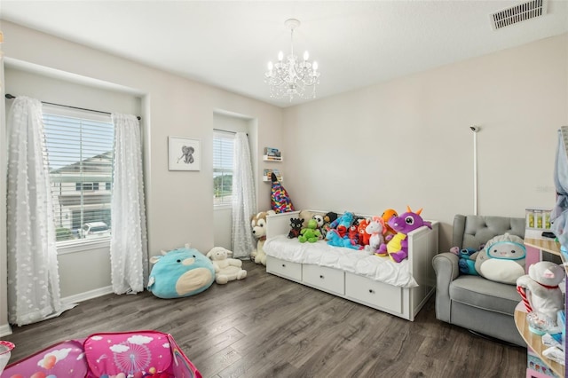 bedroom featuring visible vents, baseboards, a notable chandelier, and wood finished floors