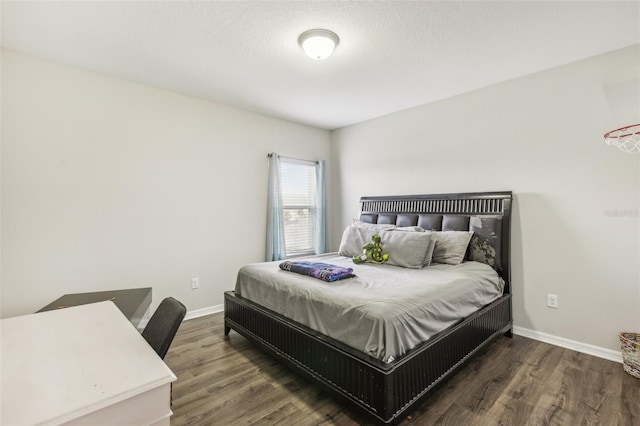 bedroom with a textured ceiling and dark hardwood / wood-style flooring