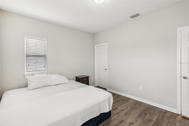 bedroom with visible vents, baseboards, and dark wood-style flooring