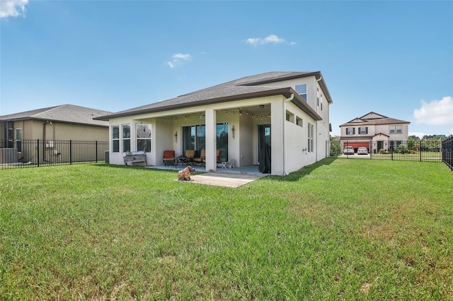 rear view of house featuring a patio area, a lawn, a fenced backyard, and stucco siding